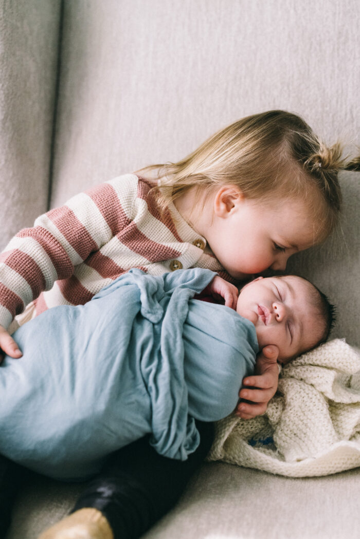 Lifestyle Newborn Photographer in New Hampshire, Boston and New England older sister kissing baby sister