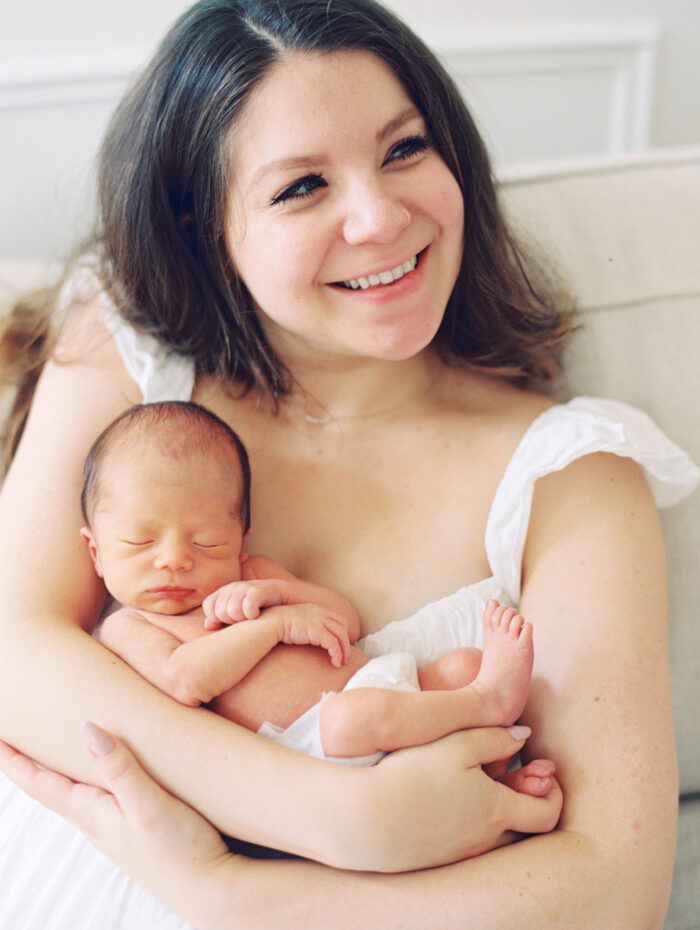 Lifestyle Newborn Photographer in New Hampshire, Boston and New England mom smiling holding newborn baby